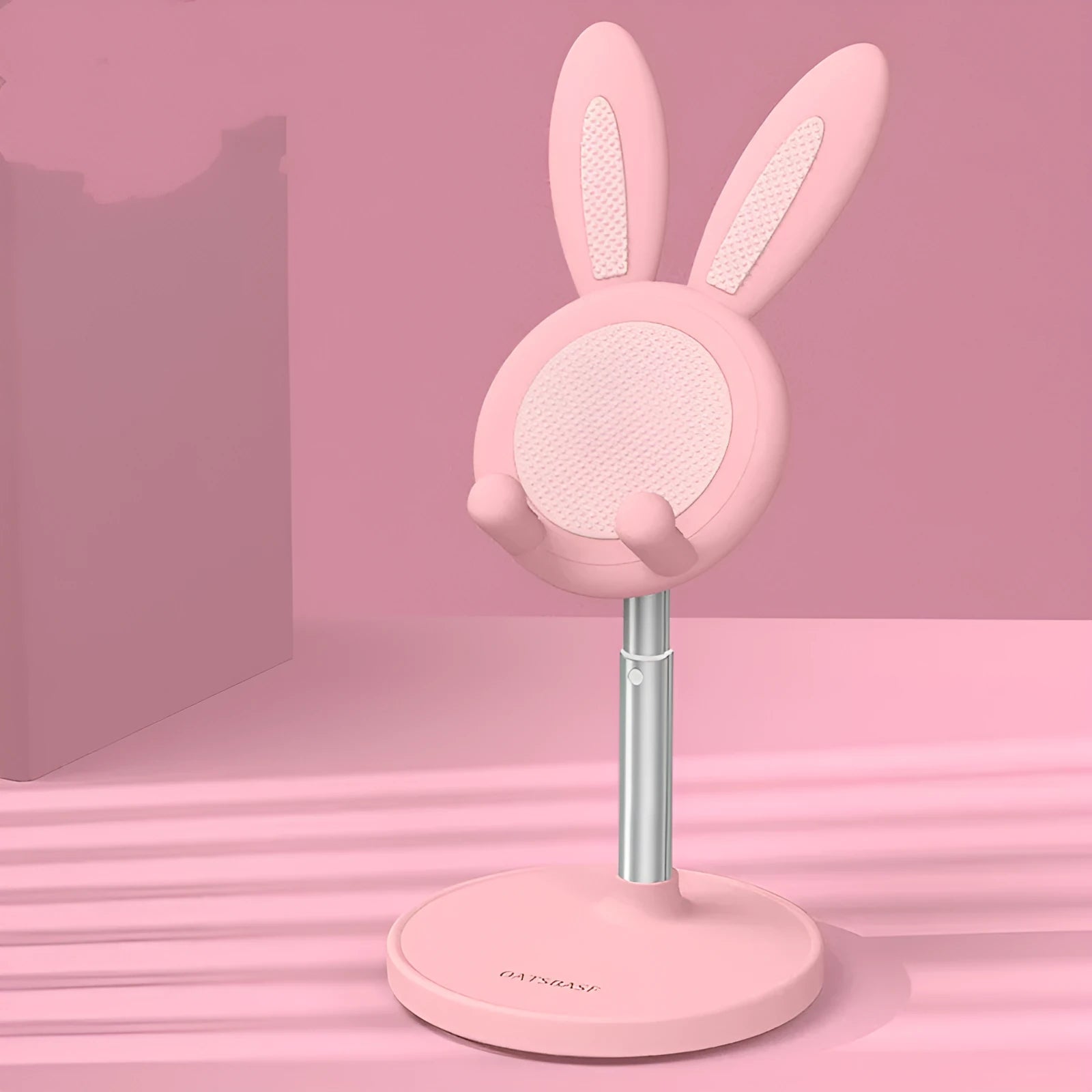 Rabbit-shaped silicone phone stand in pink on a desk with a mobile phone