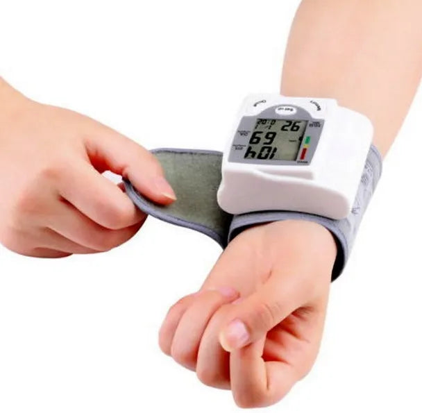 Grey wrist blood pressure monitor with ABS plastic casing showing display and cuff