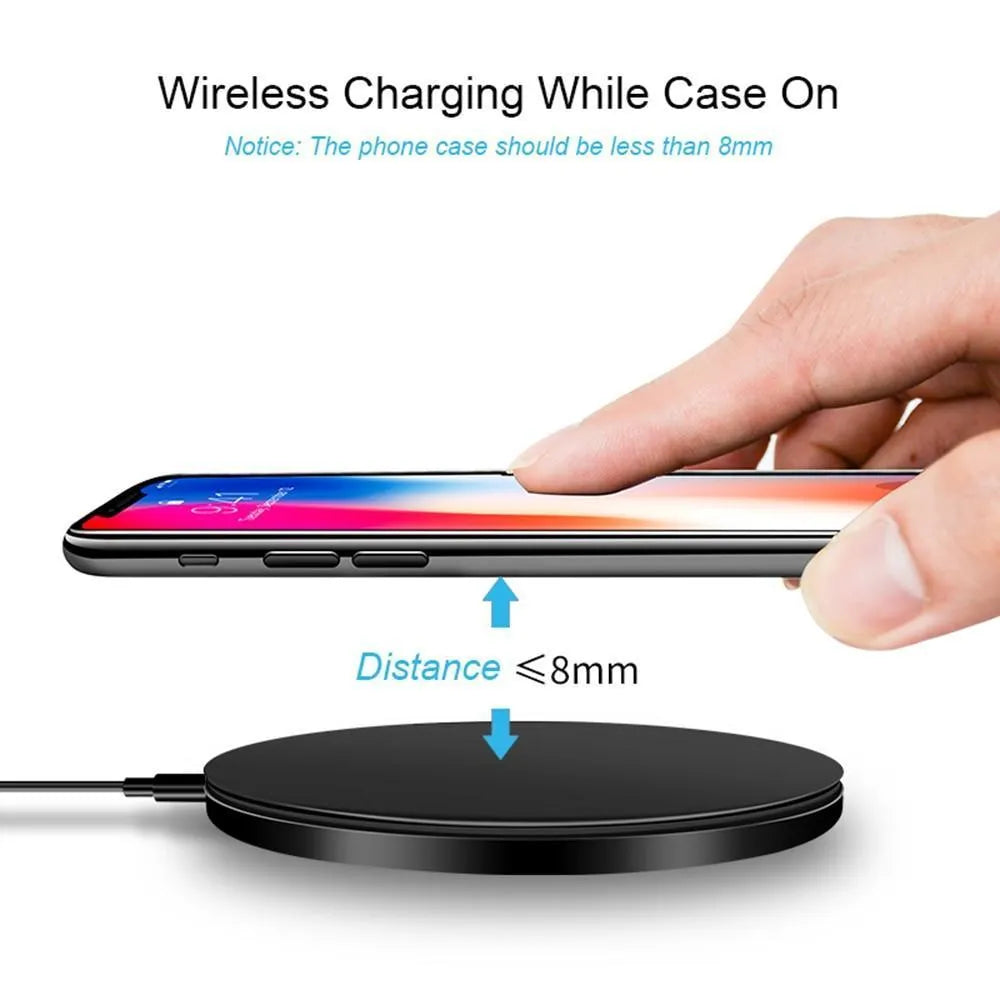 Ultra-thin black aluminium QI wireless charger with USB cable on wooden surface