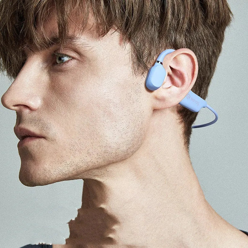 A person wearing black bone conduction Bluetooth headphones around their neck during a run.