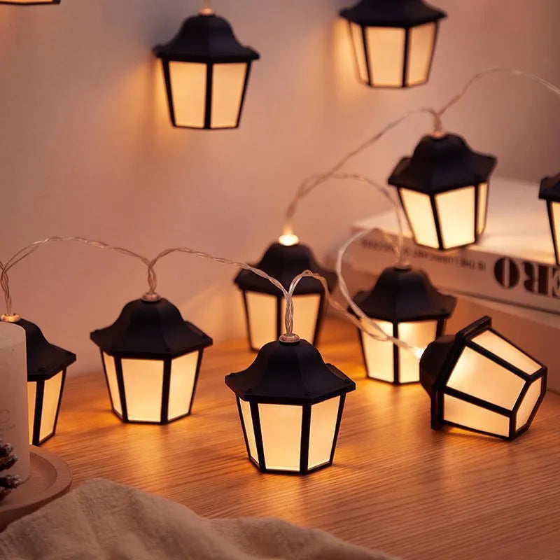Solar LED lighting chain with warm white retro lamps on a garden fence at dusk