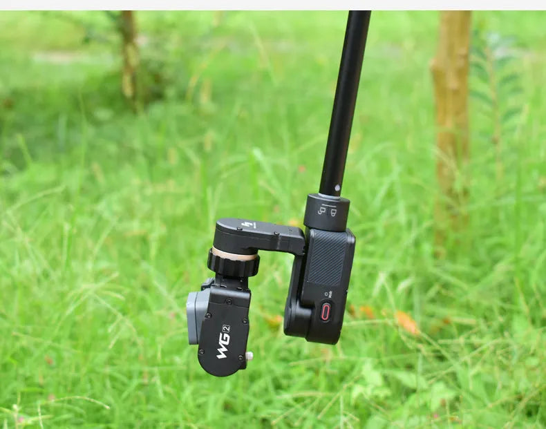 Black retractable aluminium selfie stick with phone clamp attached, shown extended and with a tripod mounted on its base.