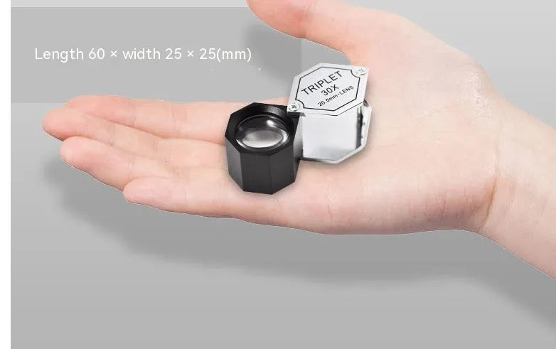 Handheld portable metal magnifying glass with optical glass lens for jewellery and coin identification.