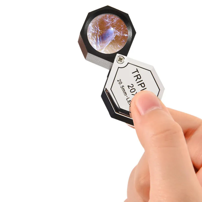 Handheld portable metal magnifying glass with optical glass lens for jewellery and coin identification.