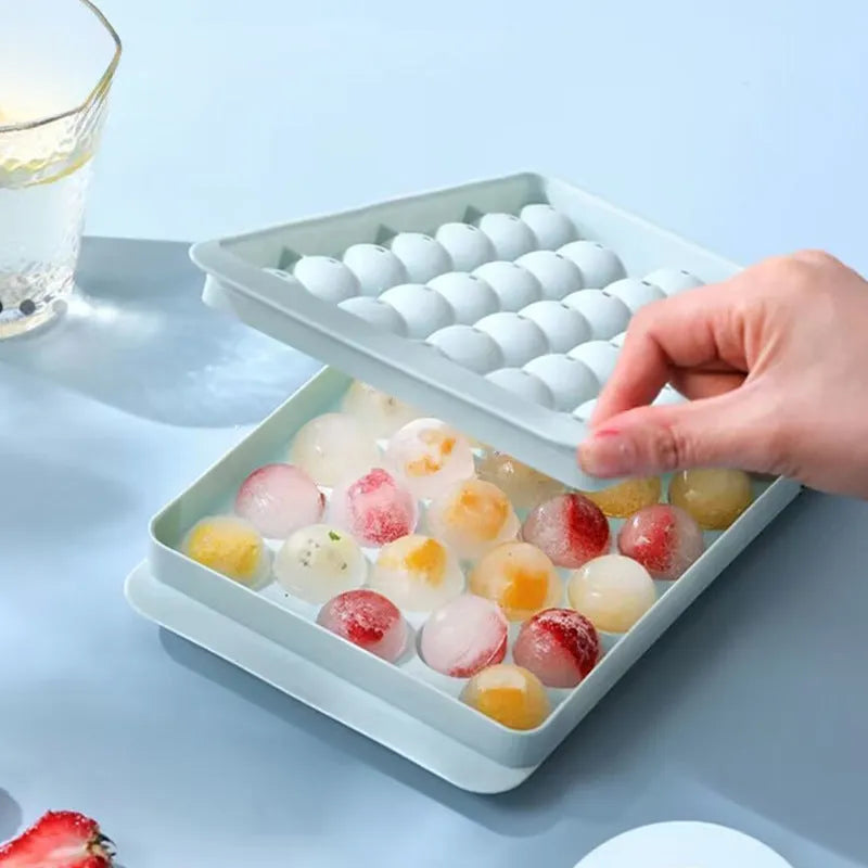 Blue flexible PE ice cube tray with lid, showing 33 round moulds, on a kitchen counter.