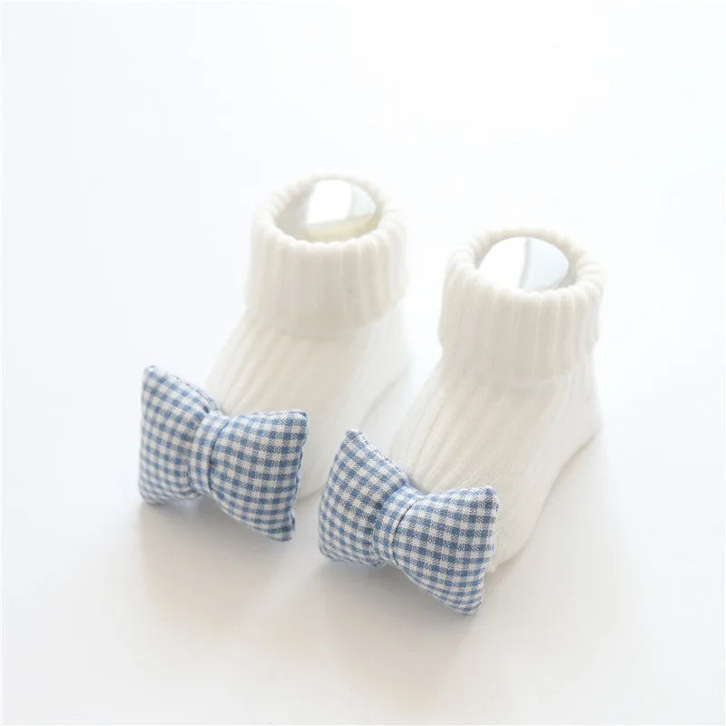 Cotton baby floor socks in assorted colours and prints like blue bow and pink stars on a size chart.