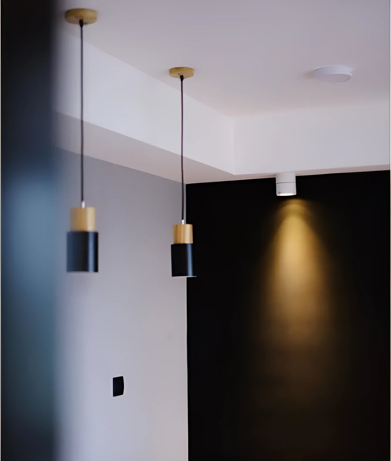 Nordic wood and wrought iron pendant light in black colour, shown above a kitchen island.