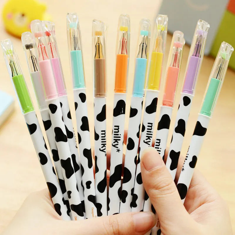 Box of 12 cow print coloured gel pens with 0.38mm fine tips on a desk.