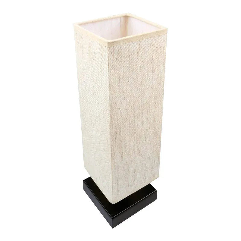 Modern simple square cloth covered table lamp 110V with E26 socket and off-white fabric shade on a desk