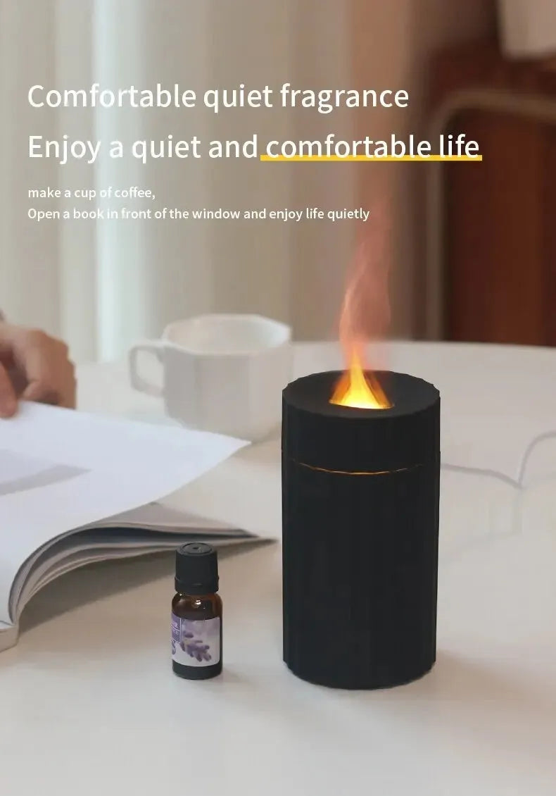 Black portable USB air humidifier and essential oil diffuser with glowing LED flame effect on a table