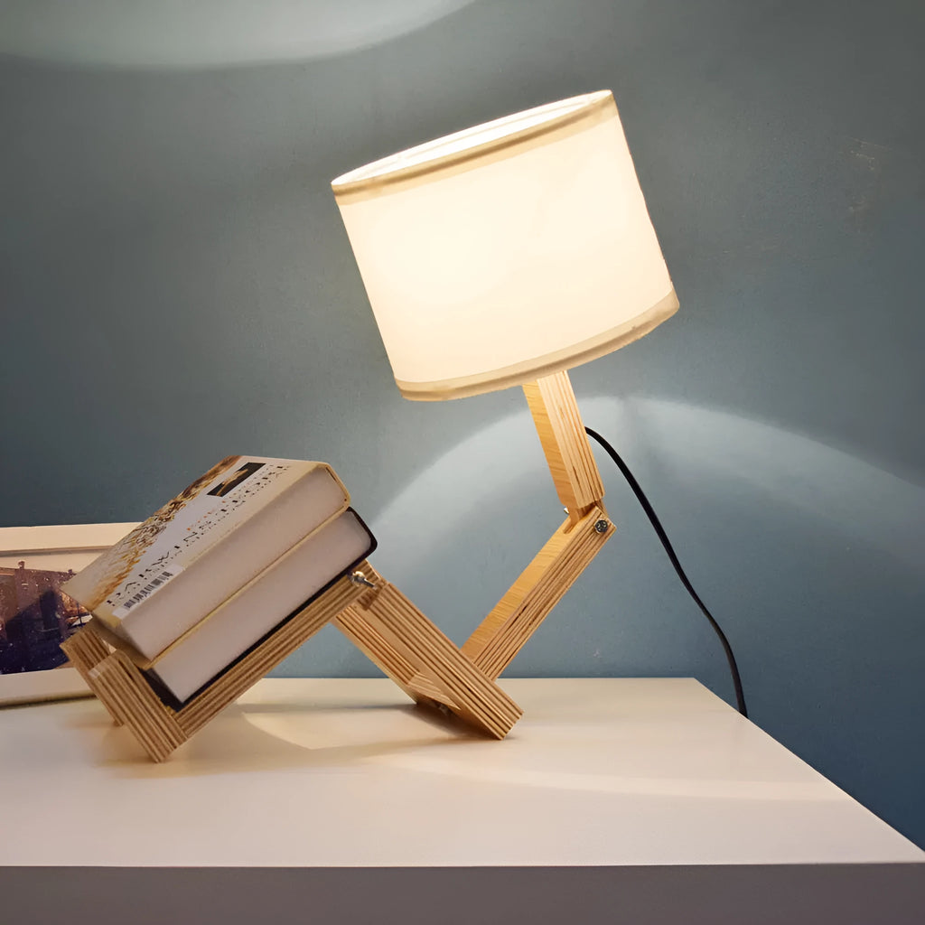Creative humanoid wooden table lamp with white fabric shade and deformable design on a wooden surface