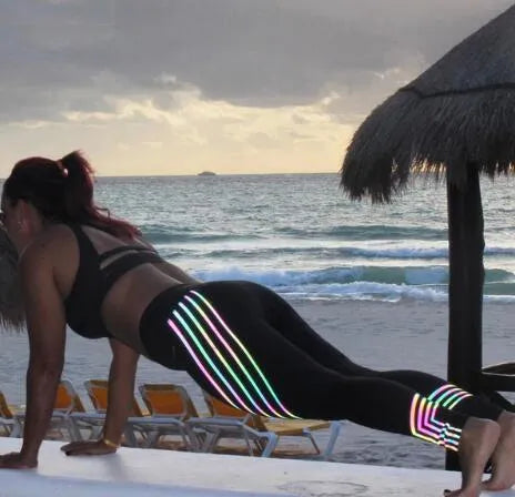 Women's black workout leggings with glowing white print pattern, showing slimming pencil pants fit.