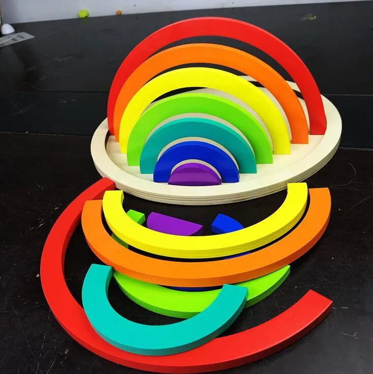 12-piece wooden arch bridge rainbow building blocks made from New Zealand pine with light lacquer finish on a flat surface
