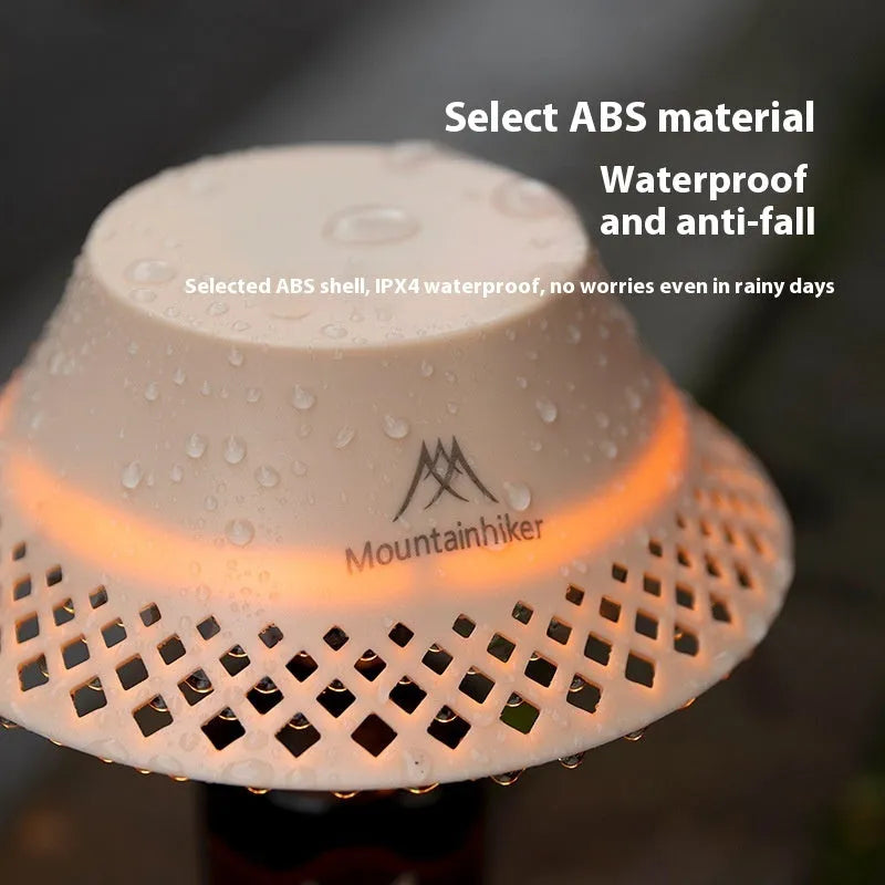 Beige rechargeable wine bottle shaped camping lantern with USB-C port and switch, shown illuminated.