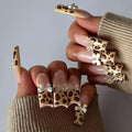 Set of plastic leopard print butterfly nail art decoration pieces on a background.