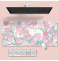 Large colourful flower pattern mouse pad on a wooden desk with keyboard and mouse.