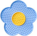 Flower-shaped silicone pet lick mat with suction cups on a smooth surface in assorted colours.