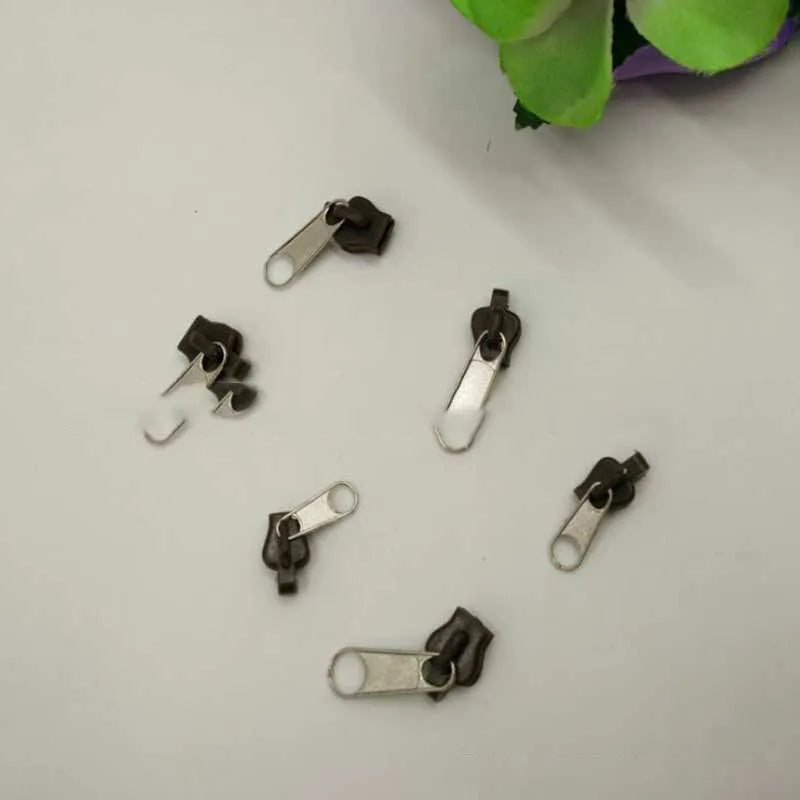 Plastic and metal zipper head replacement pieces in black, grey and brown colours