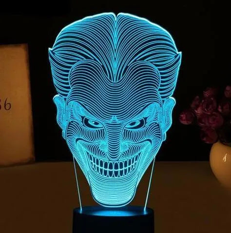 Compact USB-powered 3D LED desk lamp with a touch switch and remote control on a desk.