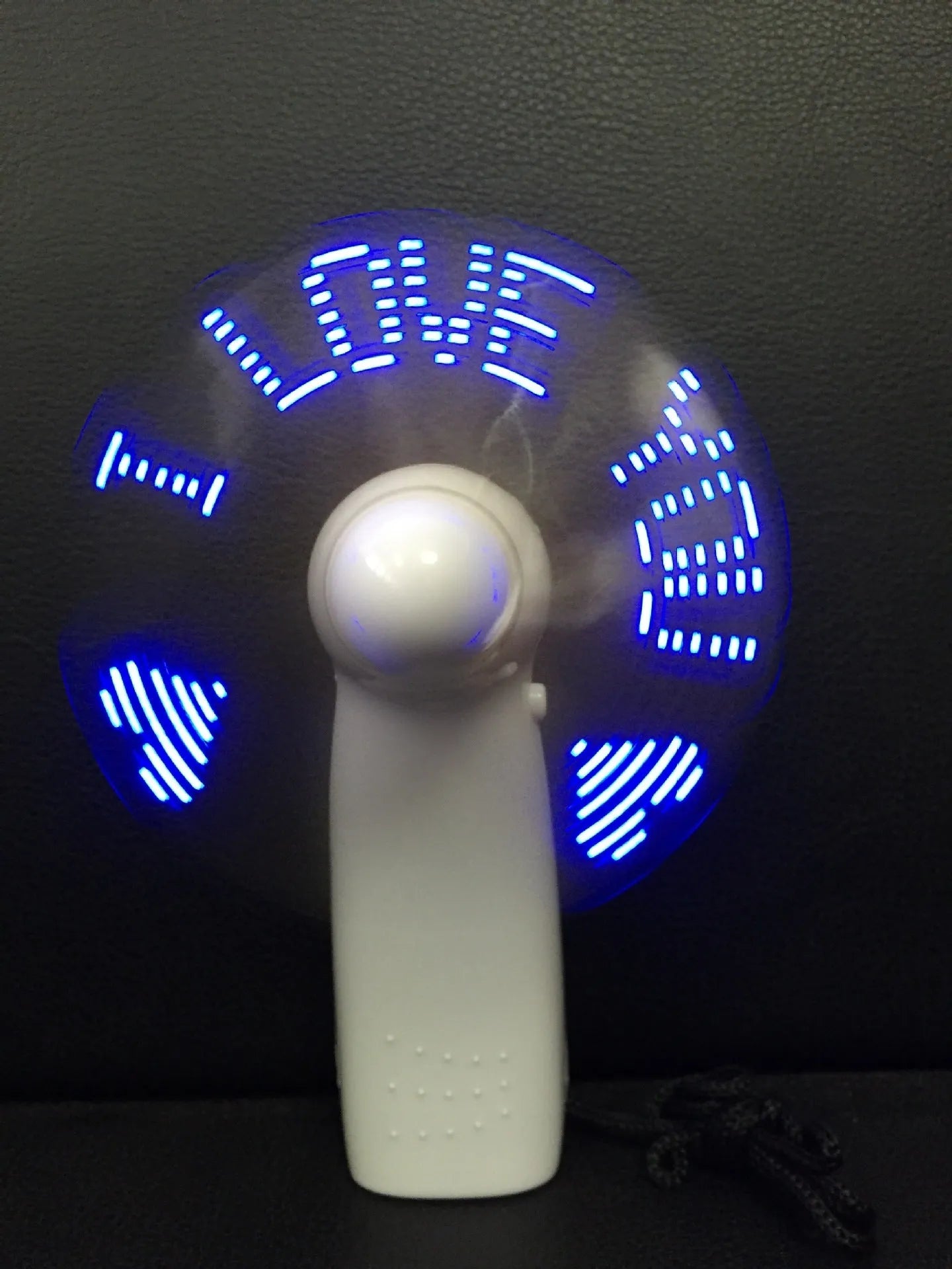 White handheld mini fan with flashing blue I Love You LED display, showing dimensions.