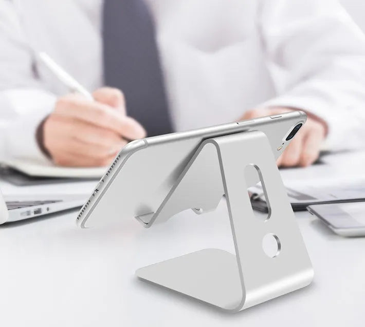 Aluminium alloy foldable phone and tablet holder in silver colour on a wooden table