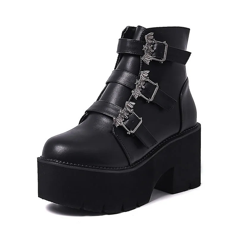 Black women's punk ankle boots with metal bat buckle and thick platform sole.