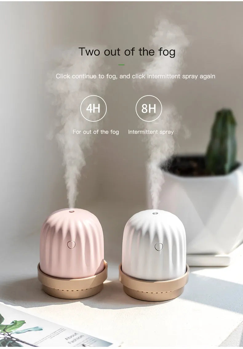 Cactus humidifier night light in green with colourful LED glow on a wooden desk