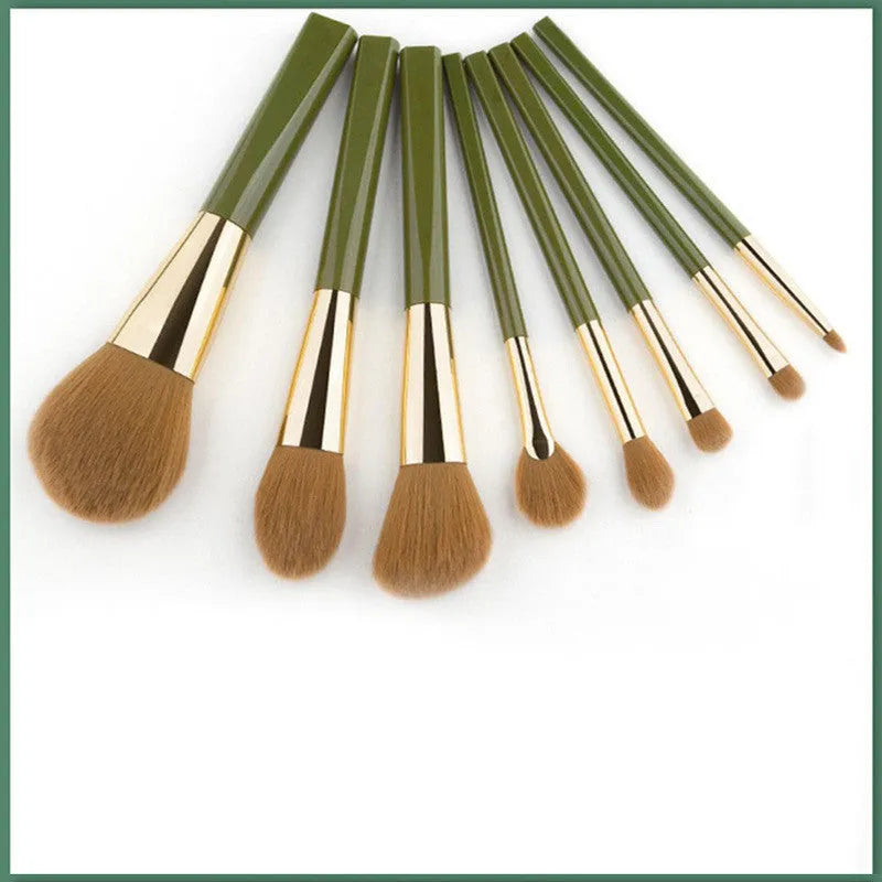 8-piece makeup brush set with man-made fibre bristles, wood handles, 17cm total length, and green shimmering PU bag