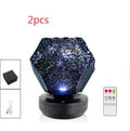 LED starry sky projector night lamp on a table projecting constellations onto a dark bedroom ceiling.