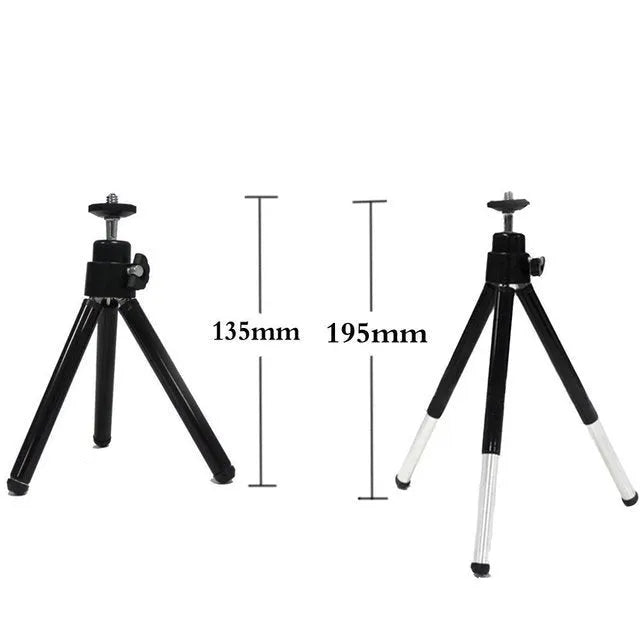 Mini aluminium tripod extended with ball head, shown alongside a U-shaped smartphone clip on a table.