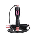 Adjustable digital skipping rope with black ABS handle and TPU coated steel cable on workout mat