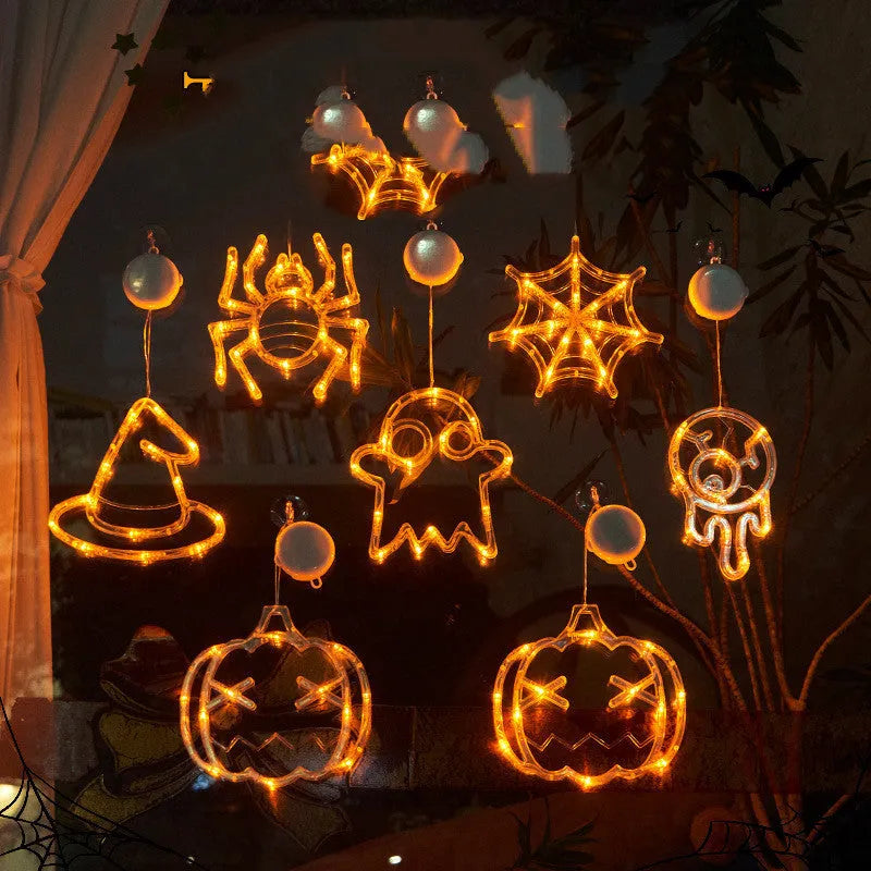 Halloween battery-powered LED window lights with spider, pumpkin and ghost figures hung by suction cups.