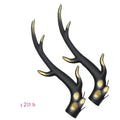 A pair of black resin dragon horn decorations for motorcycle helmet customisation, showing curved shape and mounting base.