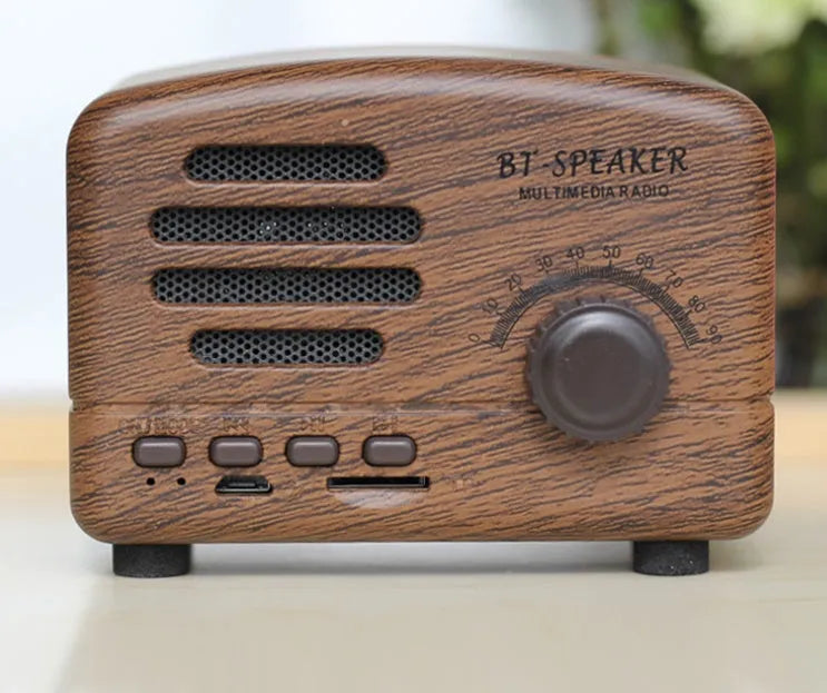 Vintage wood grain finish Bluetooth speaker with compact design on a wooden table.