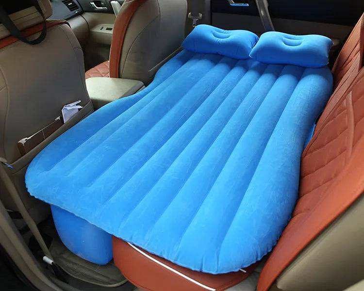 Black car inflatable bed with two pillows, shown inflated in a vehicle's rear compartment.