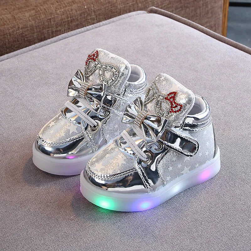 Children's LED magic button shoes with flashing lights in golden, pink, and silvery colours.