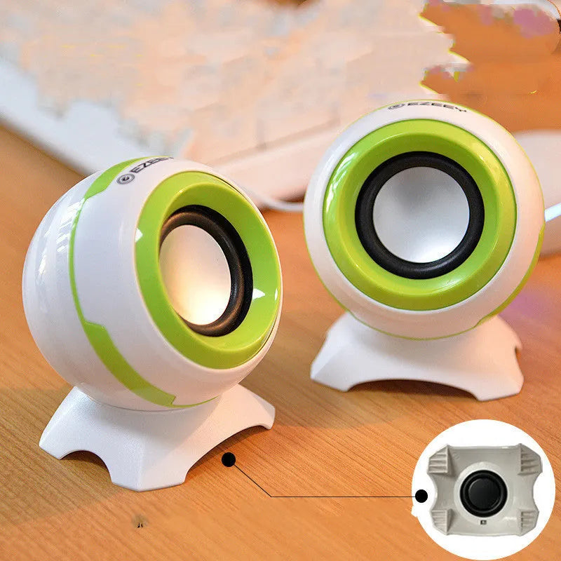 USB-powered computer stereo speakers in black gold and white gold metallic finishes beside laptop