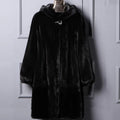 Women's long black faux fur hooded coat for winter street fashion.