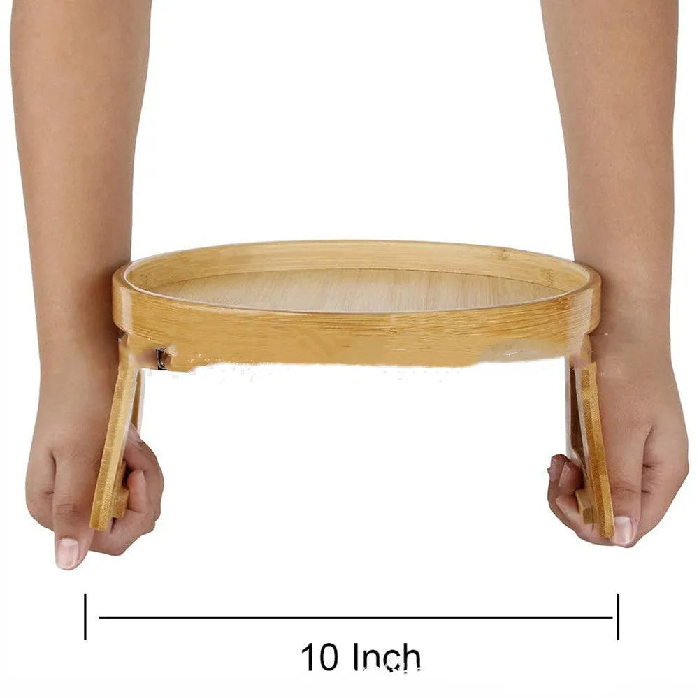 Wooden clip-on sofa tray table with carved surface in bamboo colour, attached to armrest holding snacks and remote
