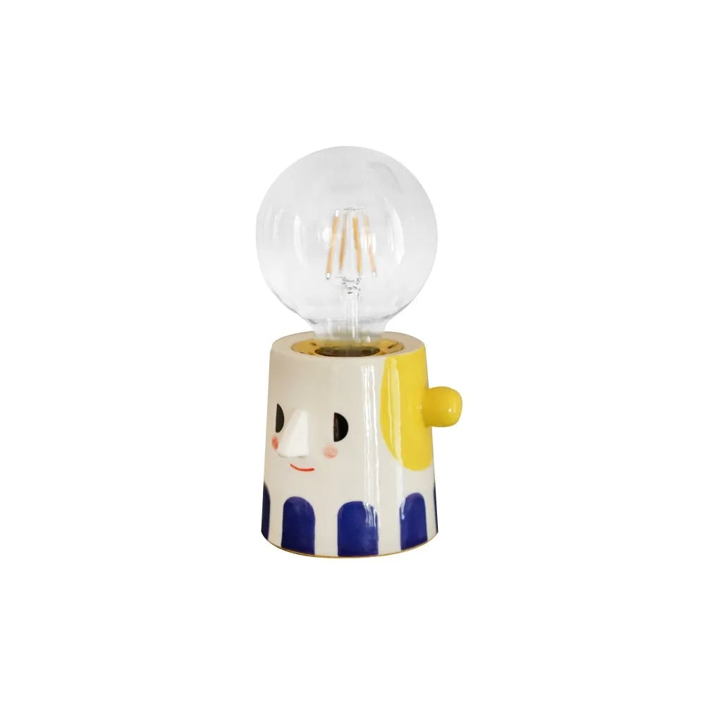Handmade solid ceramic table lamp with spherical white shade on a wooden surface, showing UK plug.