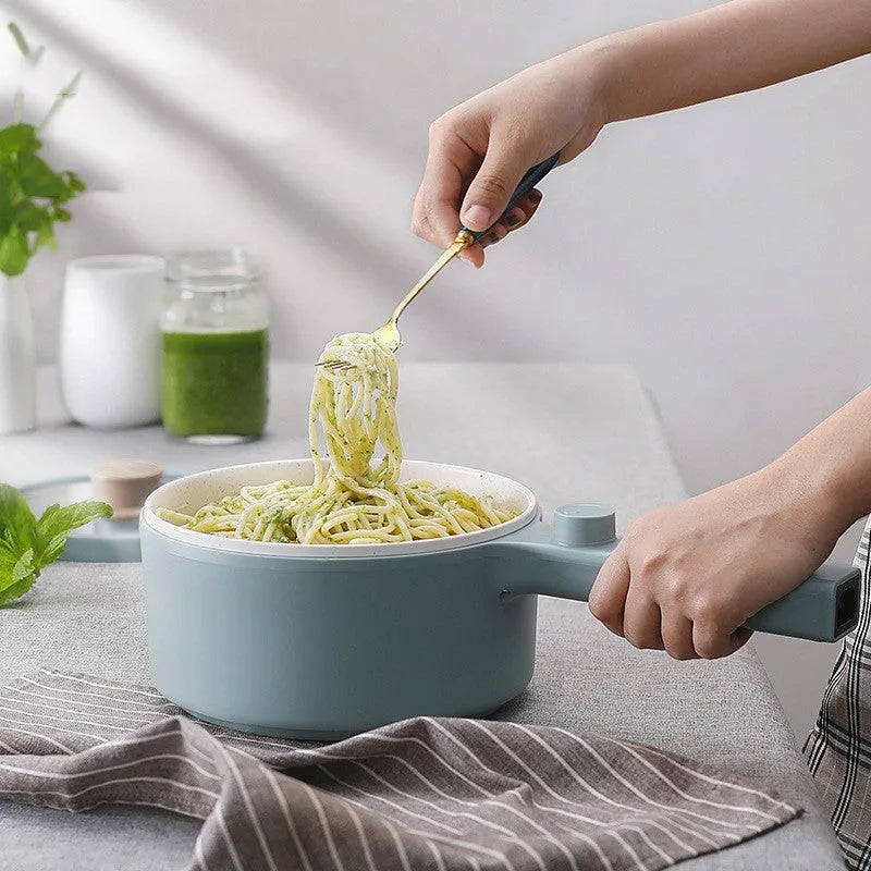 White and green multi-function electric cooking pot with temperature control dial and conversion plugs