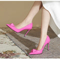 Pink patent leather women's stiletto heels with pointed toe, adjustable ankle buckle, and a slender high heel.