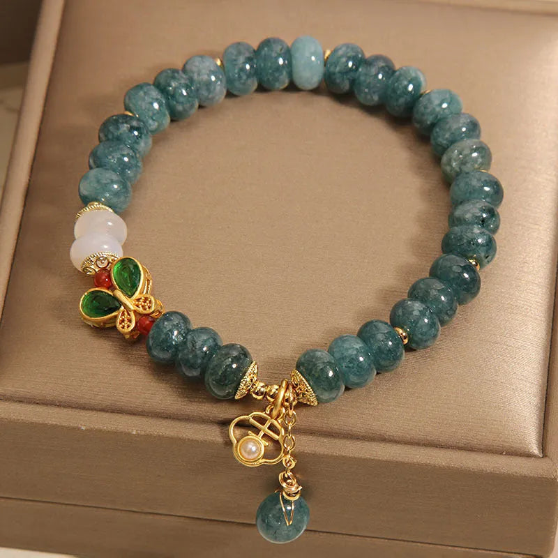 Blue water jade and white agate abacus bead bracelet with alloy inlay, rhinestones, and butterfly charm.