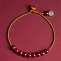 Hand-woven cinnabar bracelet with geometric design showing natural mineral colours