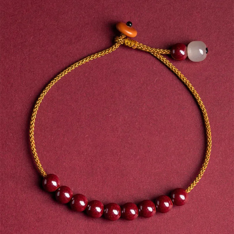 Hand-woven cinnabar bracelet with geometric design showing natural mineral colours