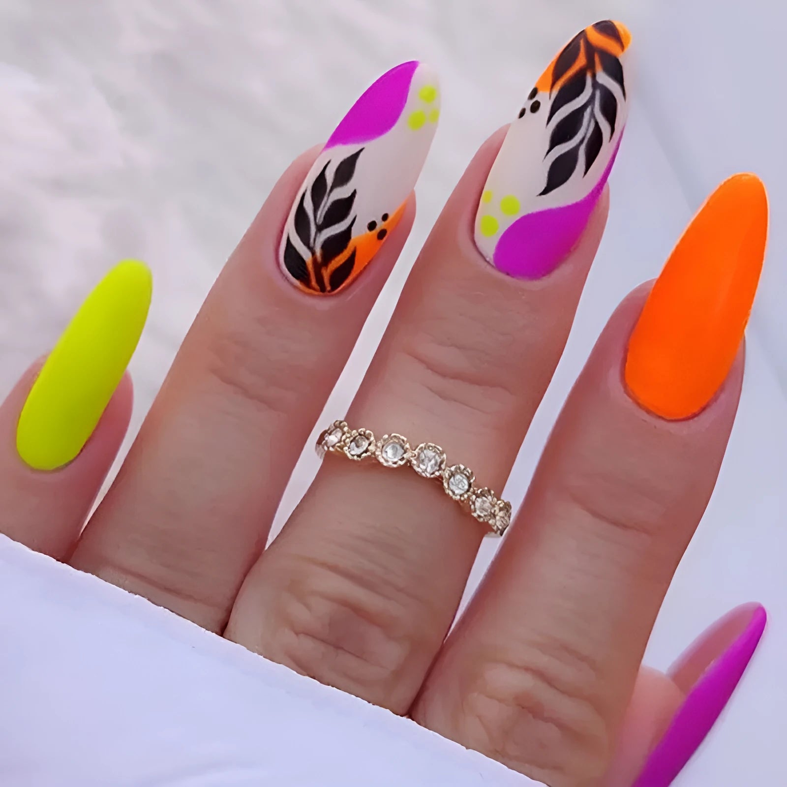 Set of four Wear Armour medium almond shaped frosted nail stickers showing French leaves, leopard print, macarons, and colourful plating designs.