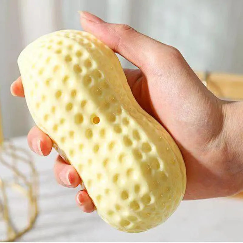 Yellow TPR peanut-shaped squeaky chew toy for dogs on a plain background.