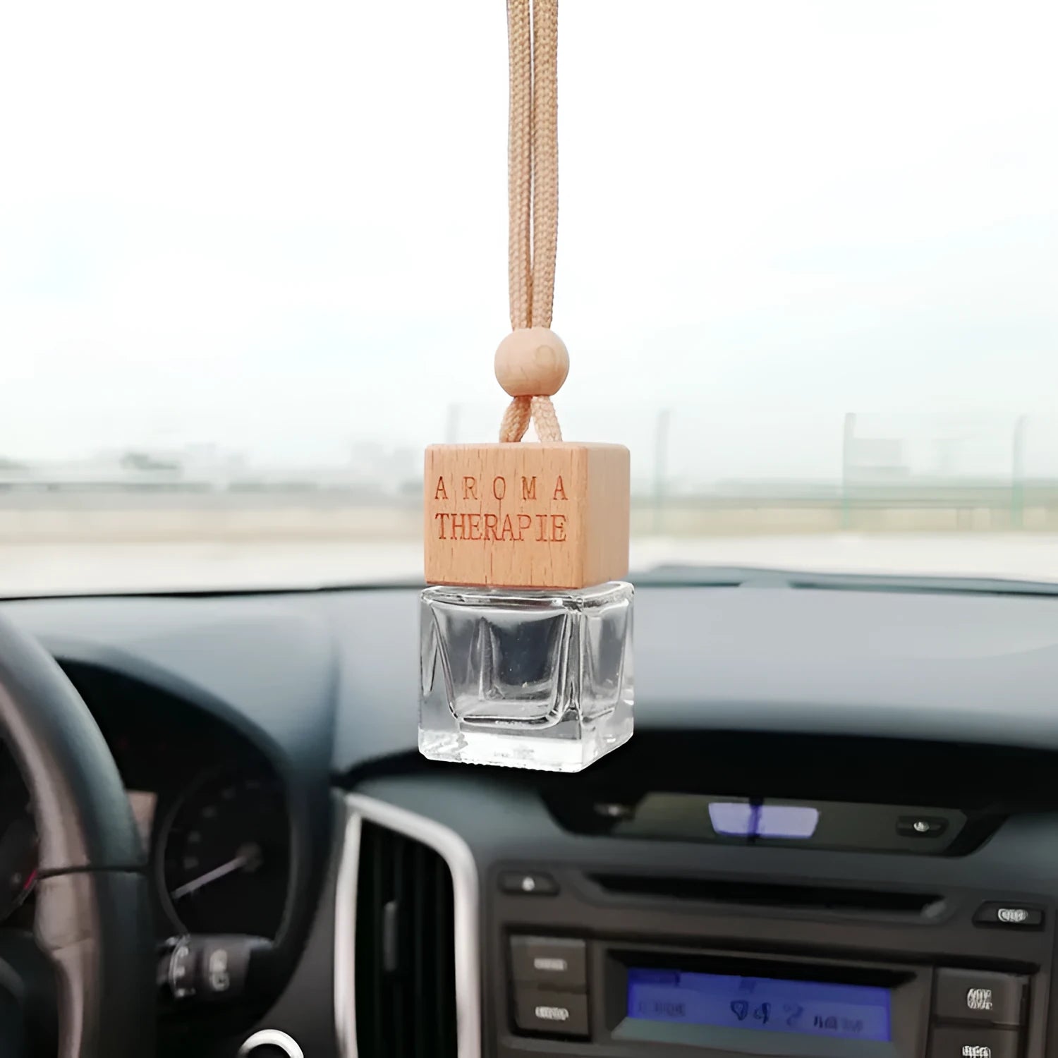Square clear glass car fragrance pendant bottle with 8ml capacity hanging from a rearview mirror