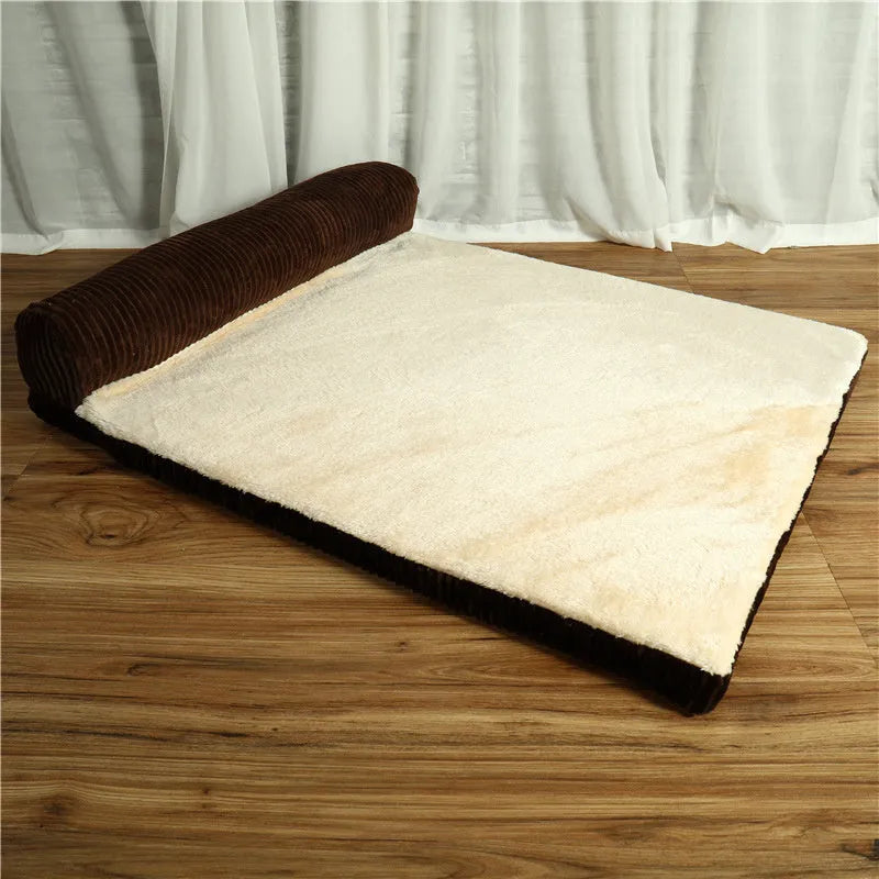 A corduroy dog sofa bed with a raised bolster side, shown in a grey colour on a wooden floor.