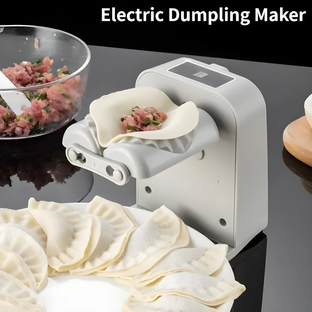 White automatic electric dumpling maker machine with USB cable, brush, and spoon on a kitchen counter.